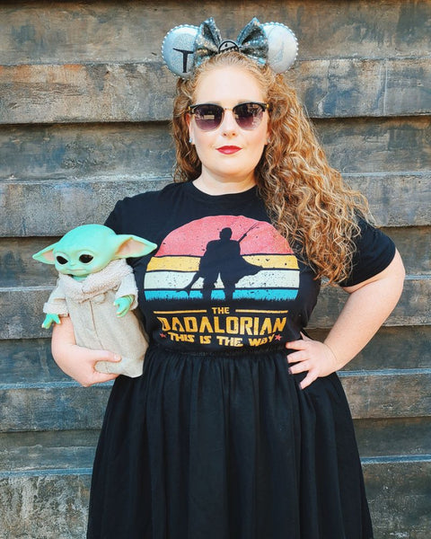 The Dadalorian Shirt This Is The Way the mandalorian mando daddy zaddy pedro pascal Star Wars dad fathers day gift outfit disney dad DILF outfit cosplay man men cotton unisex women baby yoda grogu tshirt graphic tee comic con Woman Wearing shirt at Disney World Hollywood Studios Galaxy's Edge holding grogu puppet doll with mandalorian mickey ears and sunglasses