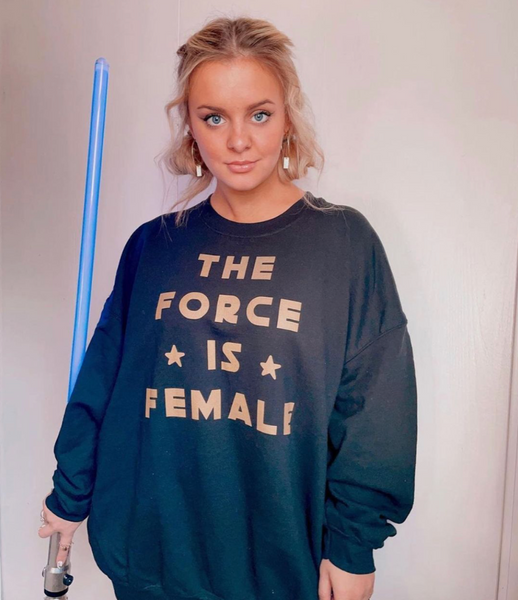 The Force Is Female Sweatshirt cotton polyester unisex women woman mom mothers day galaxy girl sweater top galaxys edge disney trip vacation outfit shirt top cosplay costume womans month girl power empowerment uplifting inspirational pink red black yellow princess leia rey ahsoka Woman Holding Blue Lightsaber staring at camera