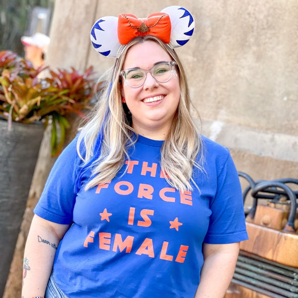 Woman wearing The Force Is Female Shirt in orange and blue with Ahsoka Tano I am No Jedi Mickey Mouse Ears at Walt Disney World in Orlando, Florida at Galaxy's Edge Batuu Hollywood Studios.