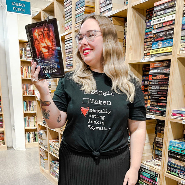 Custom Mentally Dating Shirt, personalize with your celebrity movie character crush. Mentally Dating Kylo Ren in white with red heart on black t-shirt. Size inclusive XS-4XL. Worldwide shipping. Nerdy fan merchandise outfits. Anakin Skywalker library Star Wars trilogy book in science fiction section t-shirt knot and skirt with girl with glasses