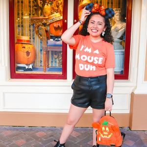 Picture of woman wearing After This We're Getting Churros Shirt in Rose Gold by Shop Friday Apparel at Disneyland Park eating a churro wearing Mickey Minnie Ears in Pink with Rainbow Cardigan Sweater