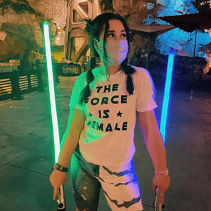 Woman wearing The Force Is Female Shirt by Shop Friday Apparel holding Ahsoka Tano Lightsabers wearing a mask at Galaxy's Edge Batuu at Walt Disney World in Florida cosplay as a Jedi