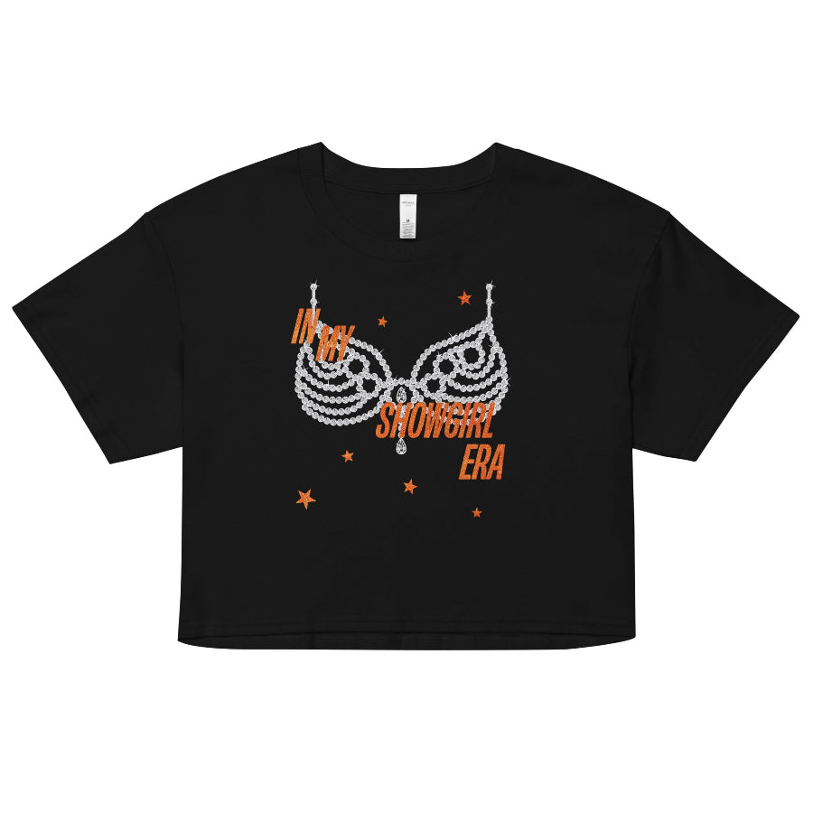 Black ‘In My Showgirl Era’ crop top with rhinestone bra graphic and orange star accents, AS Colour 4062 women’s cropped tee, relaxed fit. taylor swift graphic tee crop cropped life of a showgirl listening party movie outfit