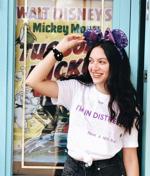 Woman wearing Meg megara hercules Damsel In Distress T-Shirt graphic tee disneyland disney world disney bound outfit shirt top t-shirt knot with purple mickey minnie ears at disneyland theme park cosplay long black hair