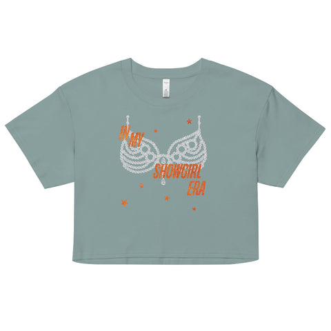Mineral Green ‘In My Showgirl Era’ crop top with rhinestone bra graphic and orange star accents, AS Colour 4062 women’s cropped tee, relaxed fit. taylor swift graphic tee crop cropped life of a showgirl listening party movie outfit