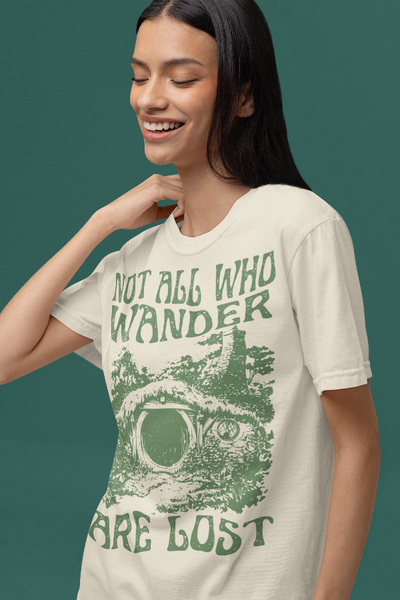 Woman wearing Lord of the Rings shirt not all who wander are lost Comfort Colors beige brown tan green Vintage Retro graphic tee unisex men women top cotton bilbo baggins quote frodo legolas aragorn gandalf the shire house gift merch LOTR