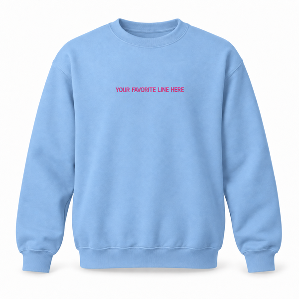Blue and pink crewneck sweatshirt with a small romance book quote embroidered across the center chest.