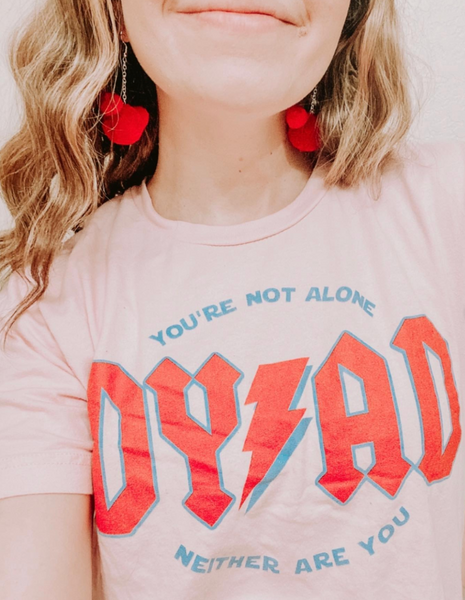 Person wearing a Reylo Star Wars t-shirt with 'DYAD' and motivational text, accessorized with Mickey-shaped red earrings.