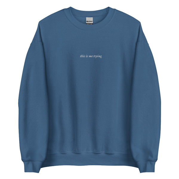 Blue unisex sweatshirt with minimalist black embroidered text reading ‘this is me trying’; folklore-inspired Swiftie aesthetic crewneck. Taylor Swift music lyrics gift outfit