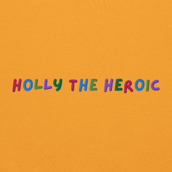 Mustard yellow unisex embroidered sweatshirt with colorful stitched text reading ‘Holly the Heroic,’ Stranger Things inspired Holly Wheeler fan design.