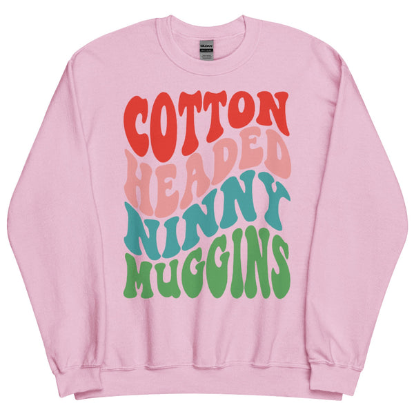 Pink unisex sweatshirt with colorful retro text reading “Cotton Headed Ninny Muggins” inspired by Elf.