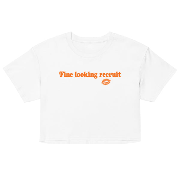 Woman wearing a white unisex graphic t-shirt with distressed orange text reading “Fine Looking Recruit” and a small orange kiss graphic.