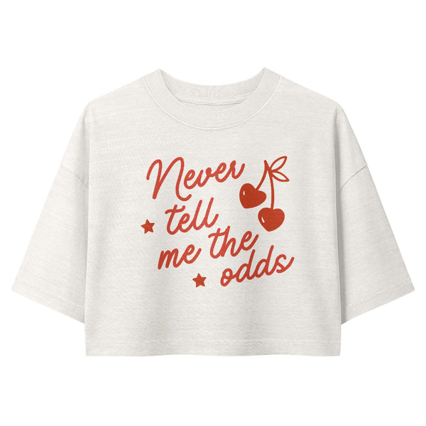 Woman wearing a vintage garment-dyed cropped tee featuring the phrase "Never Tell Me the Odds." Relaxed washed Bella + Canvas cropped t-shirt inspired by Han Solo, the Millennium Falcon, Galaxy's Edge outfits, and subtle fandom fashion.